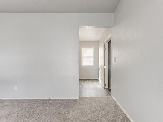 unfurnished room featuring light colored carpet