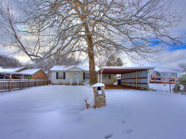 snow covered rear of property featuring a carport