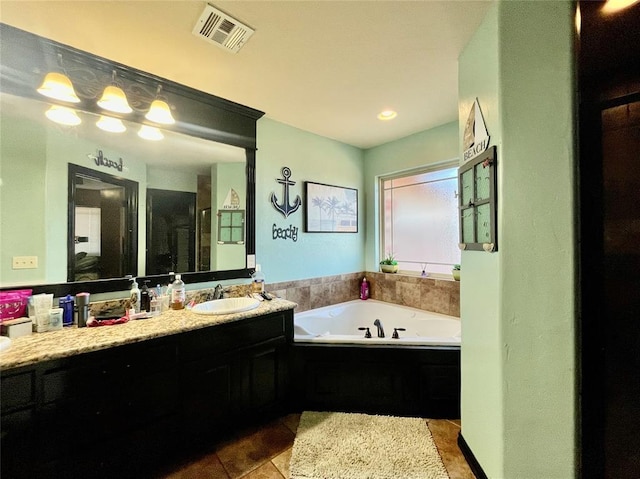 bathroom featuring a bath, tile patterned floors, and vanity