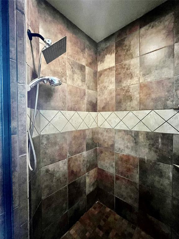 interior details featuring tiled shower