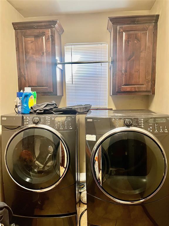 laundry room with cabinets and washer and clothes dryer