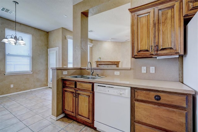 kitchen featuring sink, white appliances, light tile patterned floors, hanging light fixtures, and kitchen peninsula