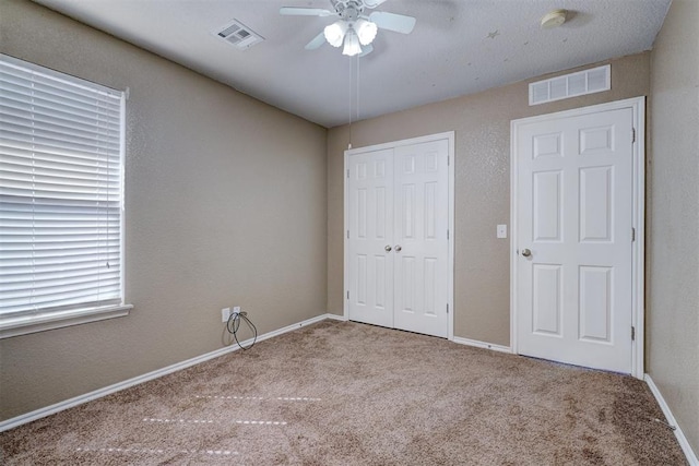 unfurnished bedroom featuring ceiling fan and light colored carpet