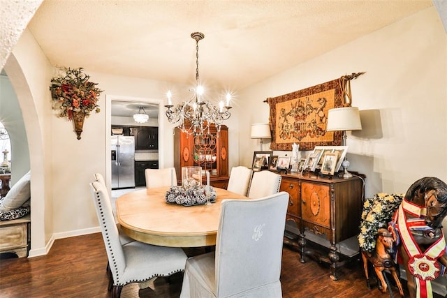 dining space featuring dark hardwood / wood-style flooring, an inviting chandelier, and a textured ceiling