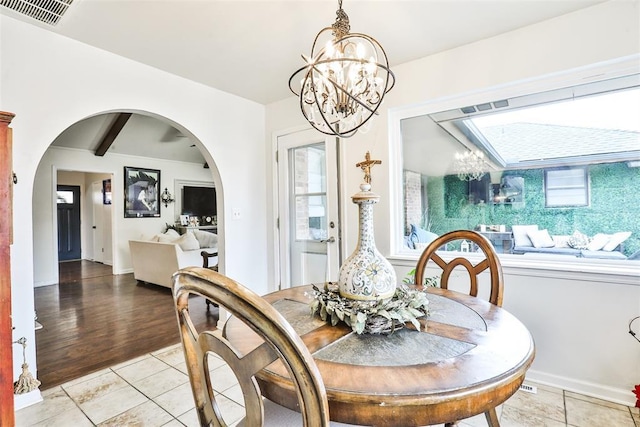 tiled dining room featuring a notable chandelier and beamed ceiling