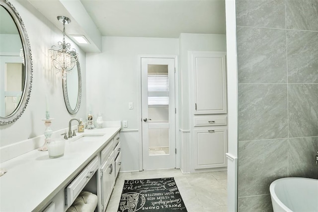 bathroom with a bath, tile patterned flooring, vanity, and a notable chandelier