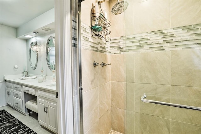 bathroom with a tile shower and vanity