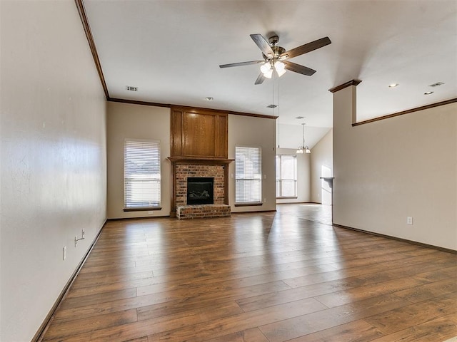 unfurnished living room featuring hardwood / wood-style floors, a healthy amount of sunlight, and a brick fireplace