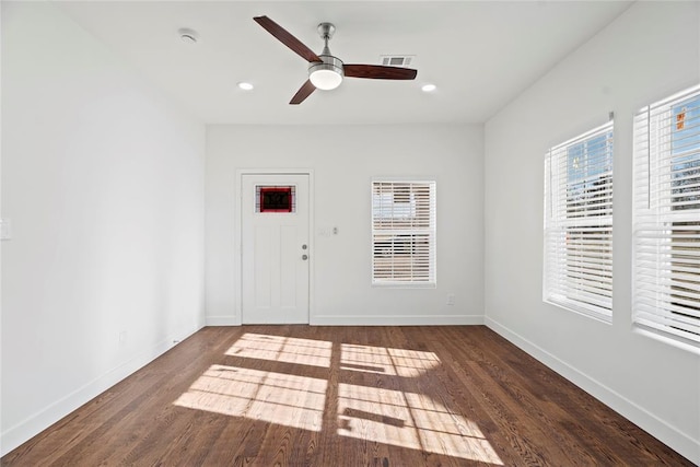 empty room with ceiling fan and dark wood-type flooring