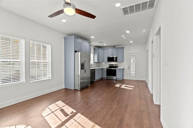 kitchen featuring gray cabinetry, ceiling fan, stainless steel appliances, tasteful backsplash, and dark hardwood / wood-style floors