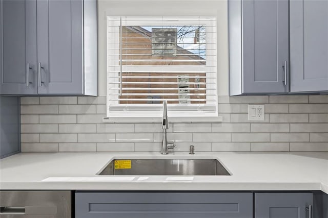 kitchen with decorative backsplash, gray cabinets, and sink