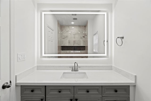 bathroom featuring vanity and tiled shower