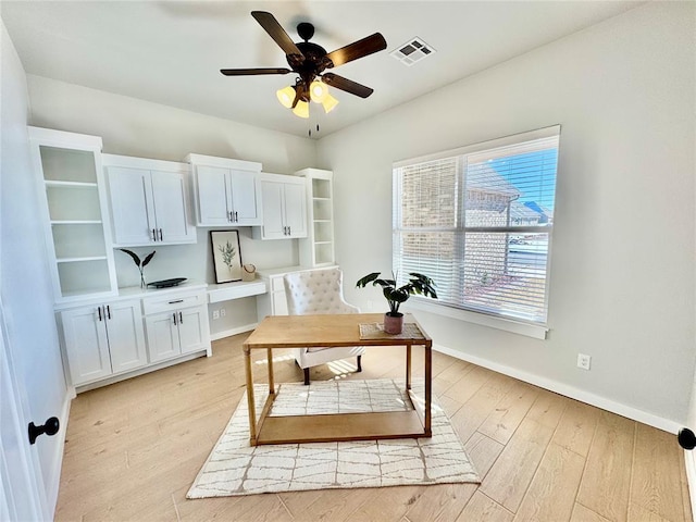 office area with light hardwood / wood-style floors, ceiling fan, and built in desk