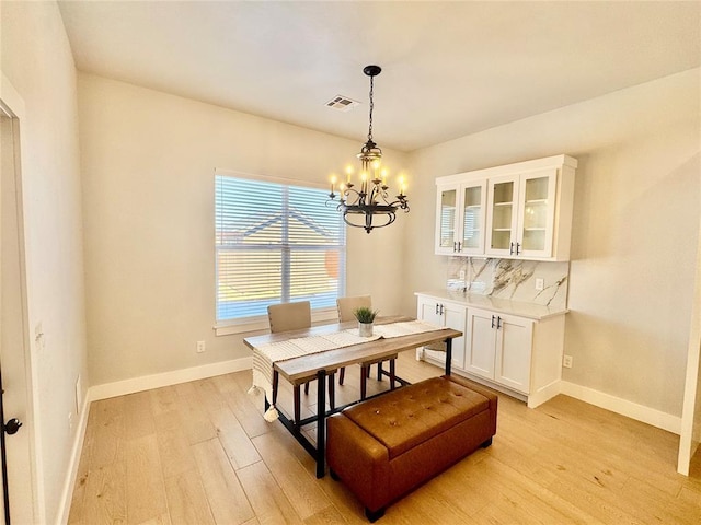 dining area featuring light hardwood / wood-style flooring and a chandelier