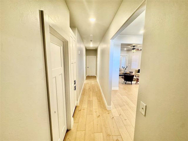 hallway with light hardwood / wood-style floors