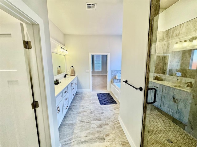 bathroom featuring vanity and independent shower and bath