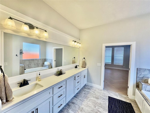 bathroom featuring a washtub and vanity