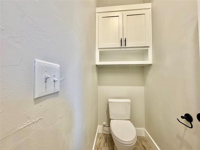 bathroom with toilet and hardwood / wood-style floors