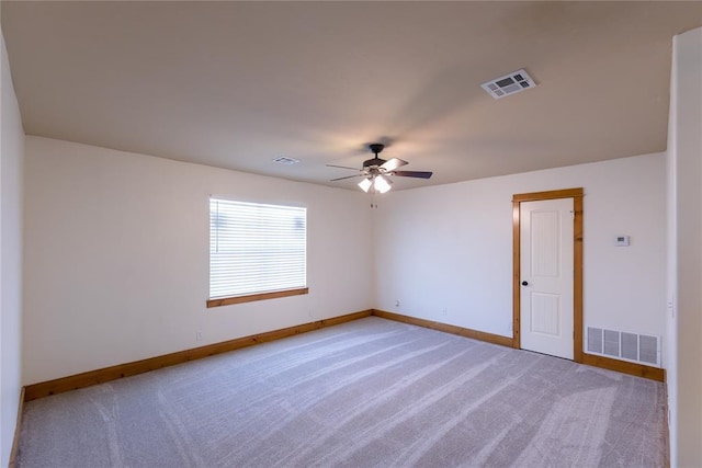 carpeted spare room featuring ceiling fan, visible vents, and baseboards