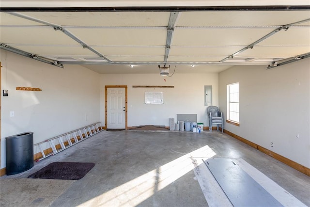 garage featuring a garage door opener, electric panel, and baseboards