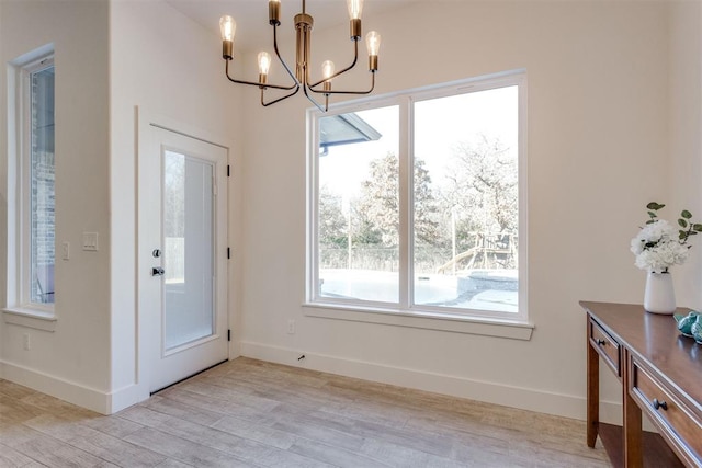 entrance foyer featuring light hardwood / wood-style flooring and a chandelier