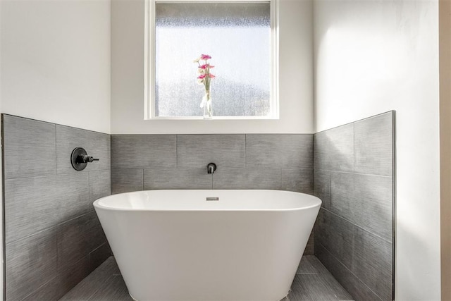 bathroom featuring a bathtub and tile walls