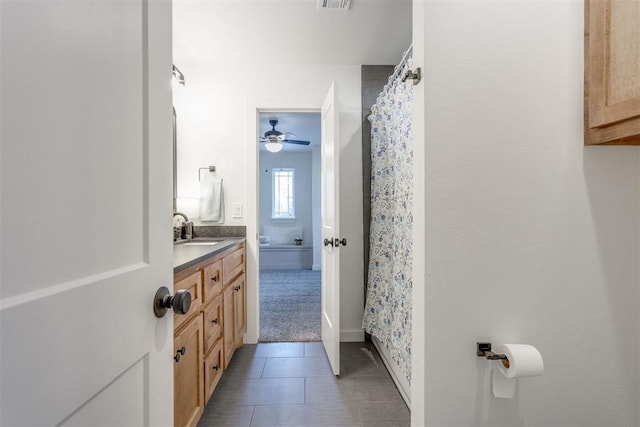 bathroom with tile patterned flooring, vanity, and ceiling fan