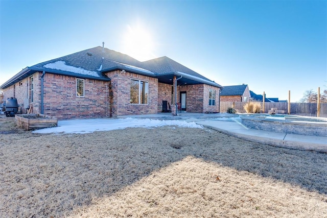 rear view of house with a jacuzzi and a patio