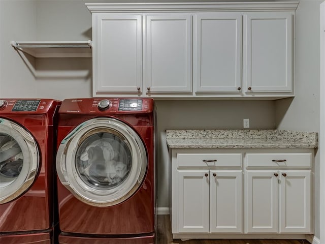 laundry area with washing machine and dryer and cabinets