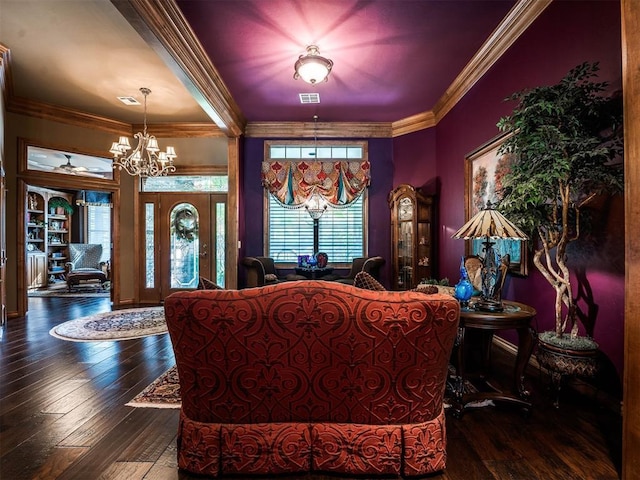 living room featuring crown molding, dark wood-type flooring, and an inviting chandelier