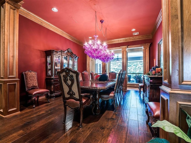 dining space featuring a notable chandelier, crown molding, ornate columns, and dark wood-type flooring