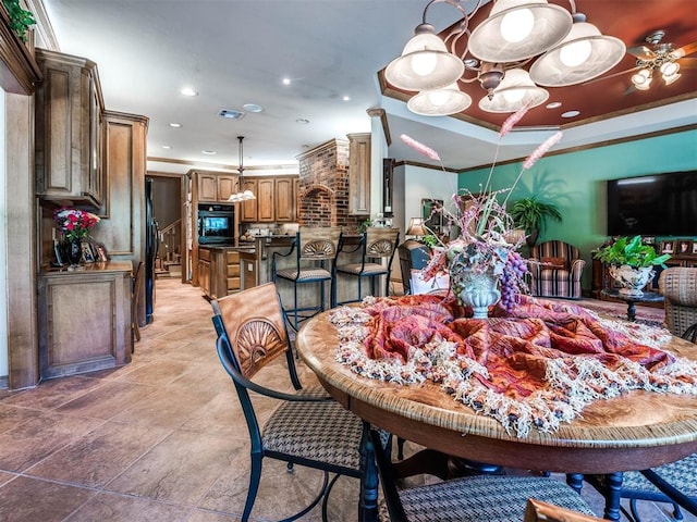 dining space featuring a raised ceiling and ornamental molding