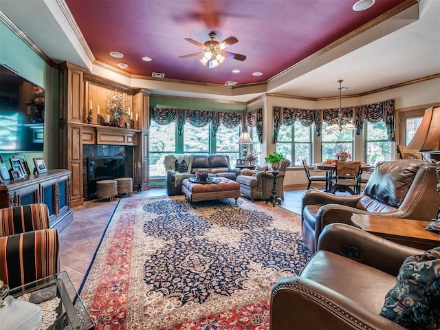 living room with a fireplace, ceiling fan with notable chandelier, and crown molding