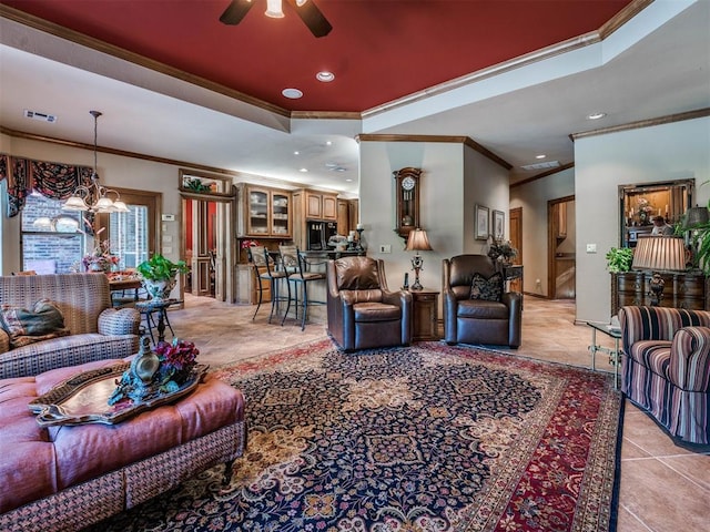 living room featuring light tile patterned floors, ceiling fan with notable chandelier, and ornamental molding