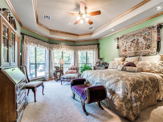 carpeted bedroom featuring a tray ceiling, ceiling fan, and ornamental molding