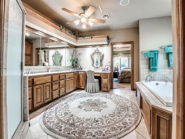 bathroom with tile patterned flooring, vanity, tiled bath, and ceiling fan