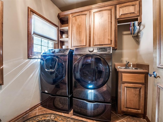 washroom with washer and clothes dryer, sink, cabinets, and dark tile patterned flooring