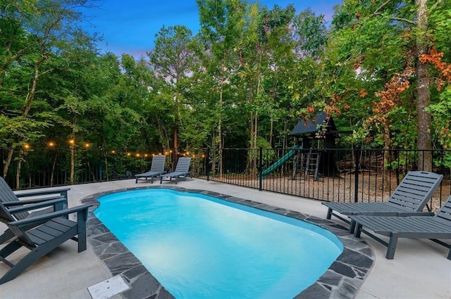 view of swimming pool with a playground