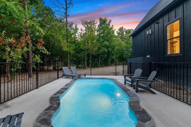 pool at dusk featuring a patio area