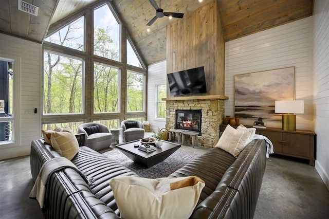 living room featuring wood walls, high vaulted ceiling, concrete floors, a fireplace, and ceiling fan