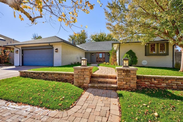 ranch-style house featuring a front yard and a garage