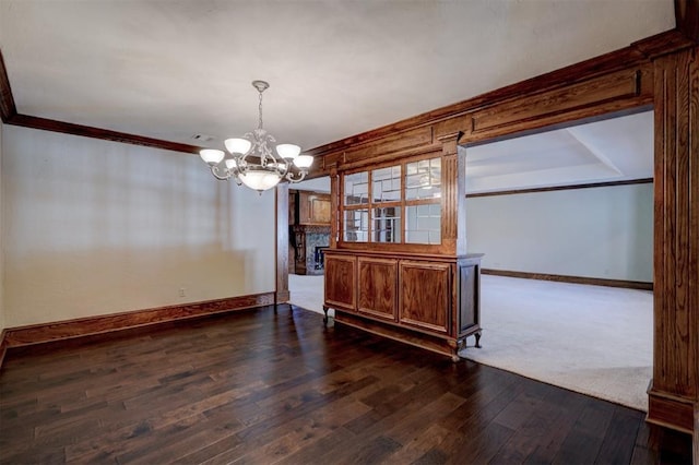 dining area with dark wood-type flooring, a notable chandelier, and ornamental molding