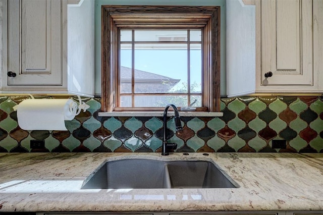 kitchen with light stone counters and sink