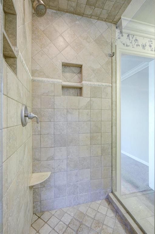 bathroom with crown molding and tiled shower