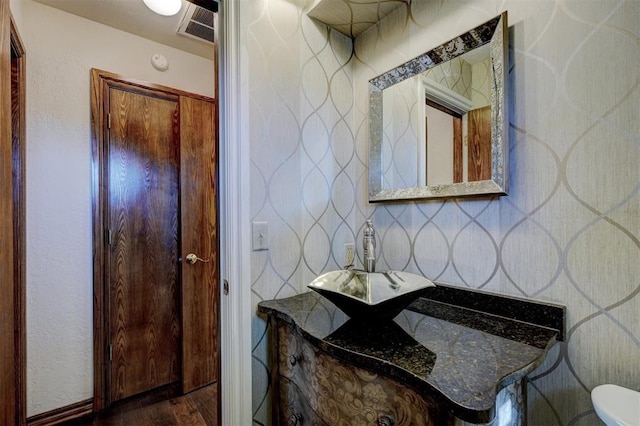 bathroom with toilet, hardwood / wood-style flooring, and vanity