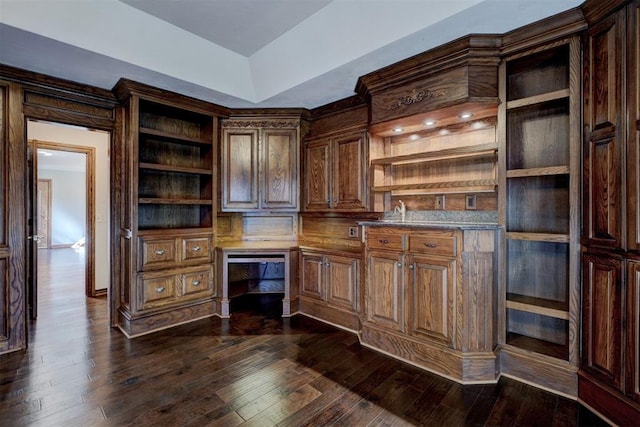 kitchen with dark hardwood / wood-style floors, dark brown cabinets, and built in desk