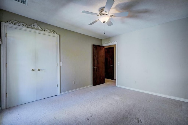 unfurnished bedroom featuring ceiling fan, a closet, and light colored carpet