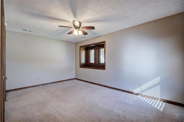 carpeted empty room featuring ceiling fan and a textured ceiling