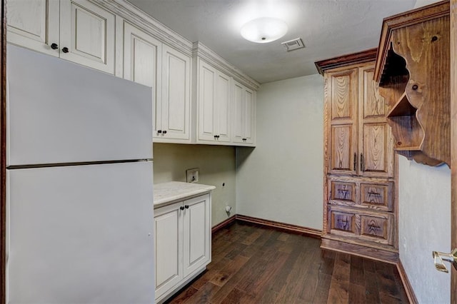 laundry room featuring dark wood-type flooring, cabinets, hookup for a washing machine, and hookup for an electric dryer