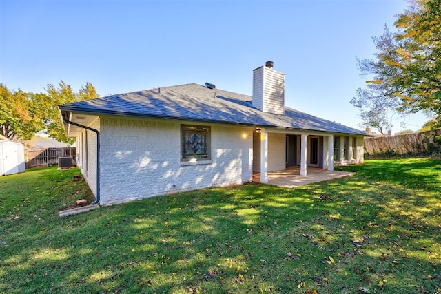 rear view of house with central air condition unit, a yard, and a patio